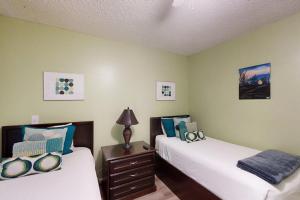 a bedroom with two beds and a lamp on a night stand at Las Palmas Condominiums #10 in South Padre Island +13 photos