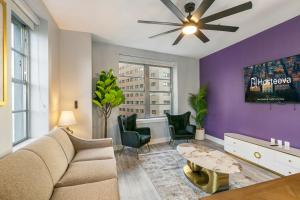 a living room with a couch and a ceiling fan at 4BD Oasis - Steps to French Quarter with Free Parking in New Orleans