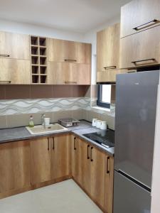 uma cozinha com armários de madeira e um frigorífico de aço inoxidável em Apartman SARA em Vršac