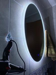 espejo en la pared del baño con secador de pelo y secador de pelo en Maison D’artiste en Tirana