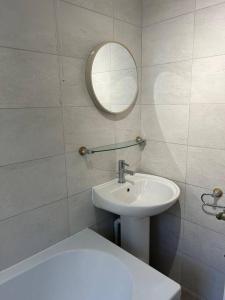 uma casa de banho branca com um lavatório e um espelho em Atlantic House, Walking Distance to Cardiff Bay and City Centre with Parking em Cardiff