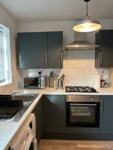 a kitchen with a sink and a stove top oven at Atlantic House, Walking Distance to Cardiff Bay and City Centre with Parking in Cardiff