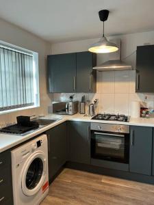 a kitchen with a washing machine and a washer at Atlantic House, Walking Distance to Cardiff Bay and City Centre with Parking in Cardiff