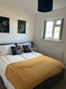 a bedroom with a bed with a yellow blanket on it at Atlantic House, Walking Distance to Cardiff Bay and City Centre with Parking in Cardiff
