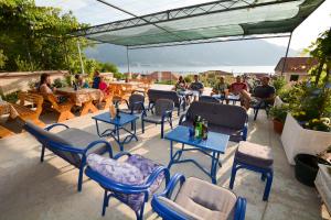 a patio with chairs and tables and people sitting at tables at Apartments Kaludjerovic in Kotor