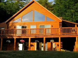 a large log cabin with a large deck at Mad River Cozy Cabin in Campton