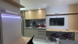 a kitchen with a sink and a counter with chairs at Book Sampa Studio 263A Lume - Alto da Boa Vista in Sao Paulo