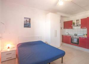 a room with a bed and a kitchen with red cabinets at Pesciolino Rosso in Campese