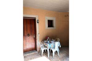 a table and chairs in a room with a door at Pesciolino Rosso in Campese