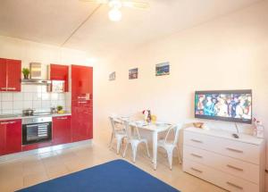 a kitchen with a white table and red cabinets at Pesciolino Rosso in Campese
