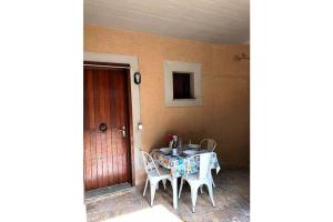 a table and chairs in a room with a door at Pesciolino Rosso in Campese