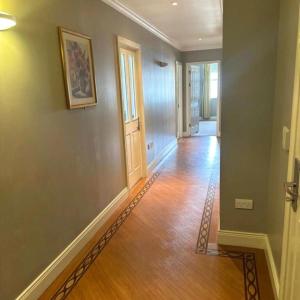 un pasillo vacío con suelo de madera y puerta en Spacious 2 bedroom apartment in Killarney en Killarney