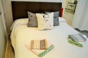 ein Bett mit zwei Handtüchern und Kissen darauf in der Unterkunft Apartamentos Garage Centro in Málaga