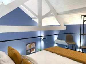 a bedroom with blue walls and a bed with a chair at MyTrip Porto in Matosinhos