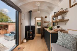 a kitchen with a stove in a tiny house at Willow, Devon Heaven Hideaways, Nr Exeter in Kenton