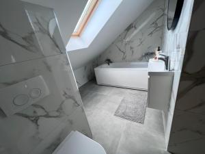 a bathroom with a white tub and a sink at Cozy Loft Apartment in Zagreb Center in Zagreb