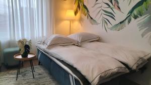 1 dormitorio con 1 cama con una planta en la pared en King Bed 4 people near Basel, Switzerland, Weil am Rhein, Loerrach, Germ'any, Near Airport, en Saint-Louis