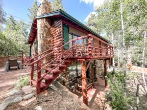 a log cabin in the woods with a tree at Mountainside Cabin / peaceful / near hiking trails in Cascade-Chipita Park