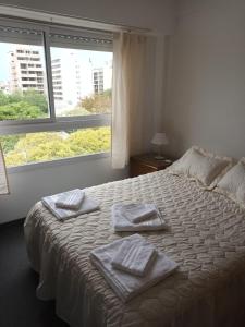 - une chambre avec un lit et des serviettes dans l'établissement DEPTO 2 Y 62 CON COCHERA PROPIA, à La Plata