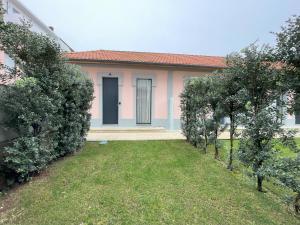 a small pink house with a yard with trees at MyTrip Porto in Matosinhos