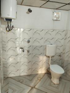 a bathroom with a toilet and a wall at sundarban jungle mahal resort in Gosāba