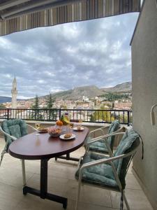 Una mesa y sillas en un balcón con vista. en Heart of Old Town Apartment, en Mostar
