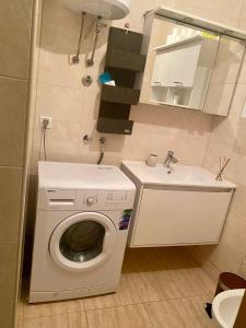 Un pequeño baño con lavadora y lavabo. en Heart of Old Town Apartment, en Mostar