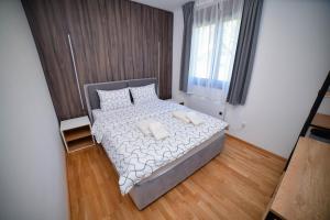 ズラティボールにあるZlatibor Breza Apartment and Spaの小さなベッドルーム(白いシーツと枕のベッド付)