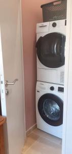 a laundry room with a washing machine and a microwave at Le chant de la rivière en Berry in Ardentes