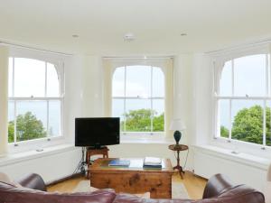 een woonkamer met 3 ramen en een flatscreen-tv bij Sea View in Shanklin