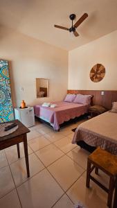 a bedroom with two beds and a ceiling fan at Canto do Rio Pousada in Vargem Bonita