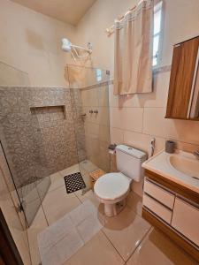 a bathroom with a shower and a toilet and a sink at Canto do Rio Pousada in Vargem Bonita