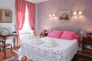 1 dormitorio con cama blanca y almohadas rosas en B&B La Boal, en Dourgne