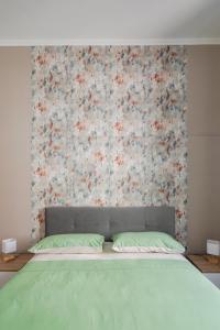 a bedroom with a bed with a floral wall at [La Casa di Rinny Circo Massimo] in Rome