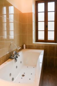 baño con bañera blanca y ventana en Gîte de la Bastide - Typique de Mirepoix, en Mirepoix