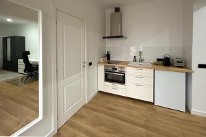 een keuken met witte kasten en een aanrechtblad bij Apartament la munte in Borşa +2 foto's