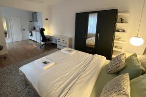 een slaapkamer met een groot bed, een bureau en een stoel bij Apartament la munte in Borşa