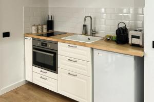 een keuken met witte kasten en een spoelbak bij Apartament la munte in Borşa