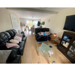 ein Wohnzimmer mit einem Sofa und einem Glastisch in der Unterkunft Hove House, 15 mins to seafront, free parking certain times in Hove