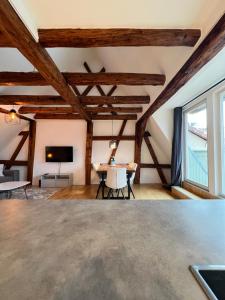 a living room with wooden ceilings and a table at LudwigsHome: Zentralste Lage, SmartTV, Terrasse in Ludwigsburg