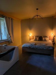 a bedroom with a bed and a tub in it at Superbe appartement avec jacuzzi et jardin privé in Marlhes