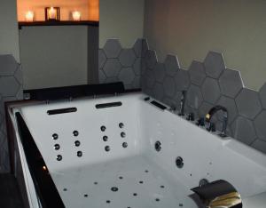 a bathroom with a bath tub with a sink at Superbe appartement avec jacuzzi et jardin privé in Marlhes
