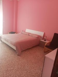een slaapkamer met een groot bed met roze muren bij B&B - Antonietta & Friends in Mercato San Severino