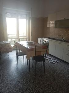 een keuken met een tafel en stoelen en een keuken met een wastafel bij B&B - Antonietta & Friends in Mercato San Severino