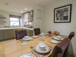 a dining room table with chairs and a kitchen at Thorneydyke Cottage in Stirling