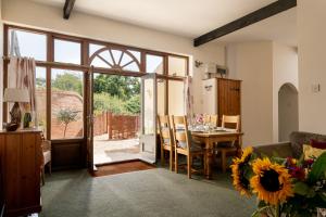 een woonkamer met een tafel en een deur naar een patio bij The Granary in Tunstead