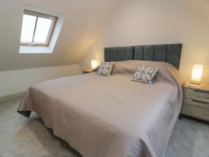 a bedroom with a large bed with two pillows on it at Thorneydyke Cottage in Stirling