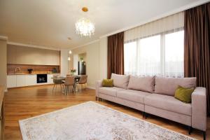 a living room with a couch and a kitchen at Modern, Spacious and Elegant Apt in Almaty