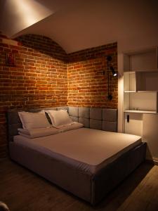 Ce lit se trouve dans une chambre dotée d'un mur en briques. dans l'établissement Котляревського апартамент з садом, à Lviv
