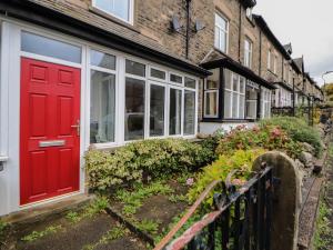 a red door on the side of a house at Badgers in Sedbergh